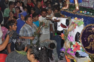 Fig.6 Un mayordomo de la virgen cuelga a un “toro de petate” la “reliquia” de canamargo o rosario de tamales. Foto: Miguel A. Méndez, 2019.